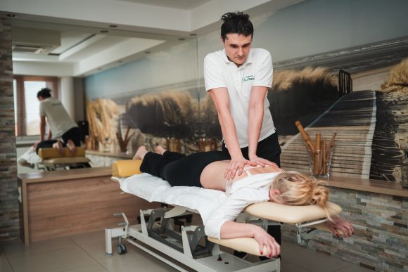 Fizjoterapeuta wykonujący zabieg chiropraktyki. galeria