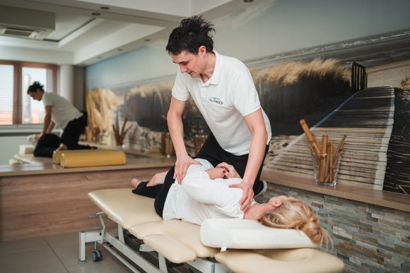 Fizjoterapeuta wykonujący zabieg chiropraktyki. galeria