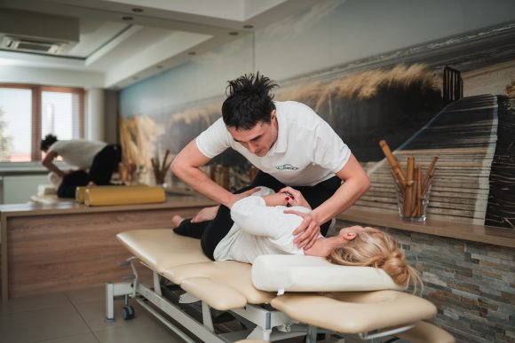 Fizjoterapeuta wykonujący zabieg chiropraktyki. galeria