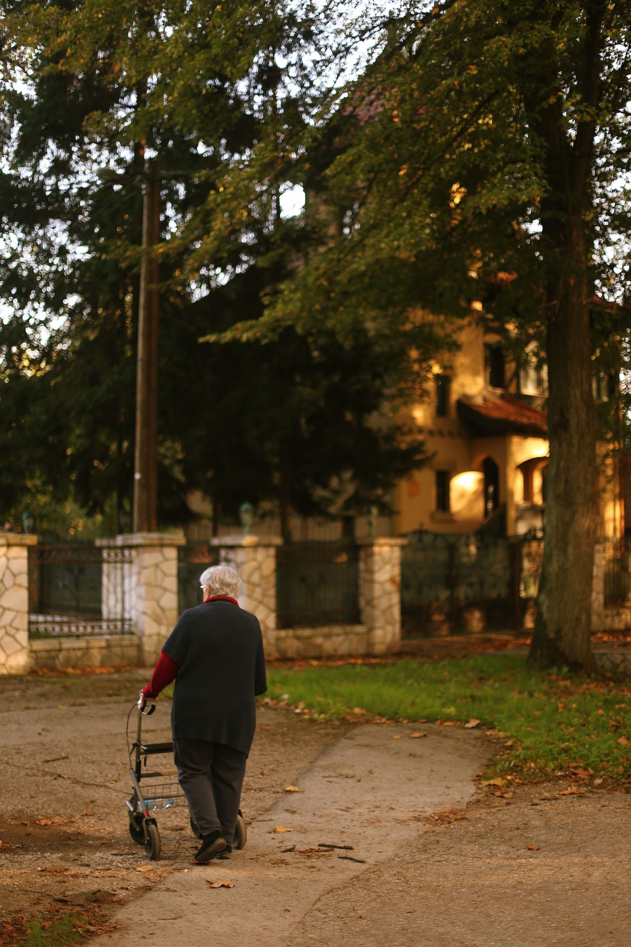 zdjęcie przedstawia starszą kobietę, która pewnie podpiera się na chodziku rehabilitacyjnym. To specjalistyczne wsparcie ułatwia jej bezpieczne poruszanie się i daje upragnioną stabilność.